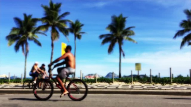 Unrecognizable people walking, jogging, biking, and skating on the beachfront street at Ipanema Beach in Rio de Janeiro Brazil