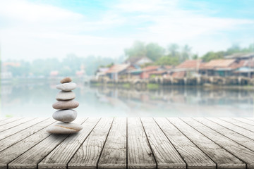 zen stones on wooden with village in Japan blurred background
