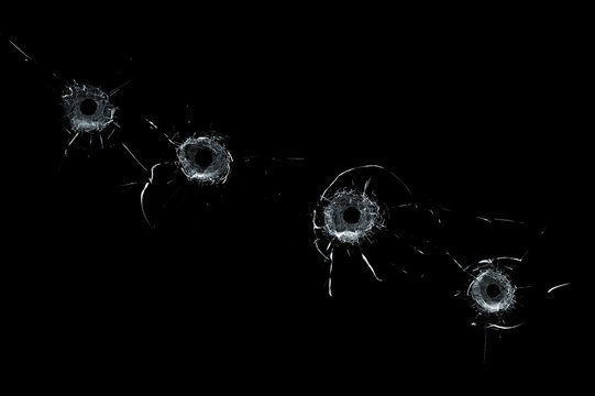 Broken glass multiple bullet holes in glass isolated on black