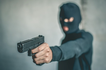 Robber with a gun robbing intimidate.Crime and robbery concept. - obrazy, fototapety, plakaty