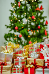 Stacks of Christmas presents under a Christmas tree.