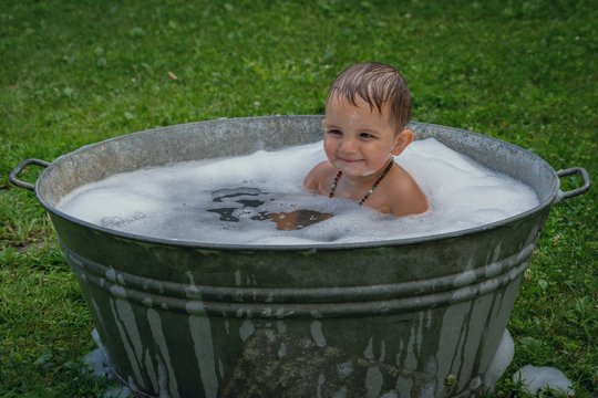 Kind das sich im Sommer im Waschzuber abk&uuml;hlt