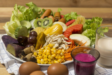 Salads ,eggs and milk placed on wooden table