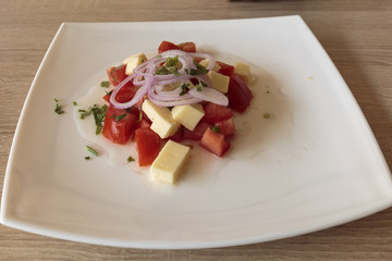 Delicious fresh salad with tomatoes, cheese and pepper. Concept of vegan food.