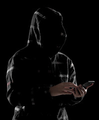 Hacker anonymous using smartphone against dark background