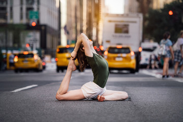 Woman doing yoga pose on city street of New York