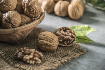 Walnuts in wooden bowl. Whole walnut on table