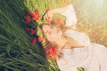 Beautiful young girl in the grass under the sun. Summer. Nature.