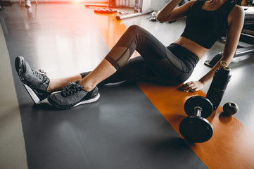 Relaxing after training.beautiful young woman looking away while sitting  at gym.young female at gym taking a break from workout.