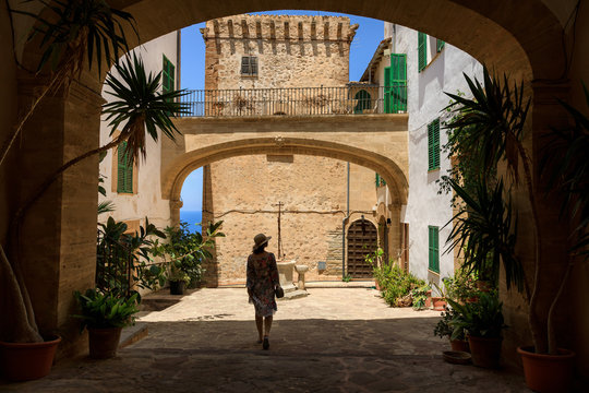 Woman in an old spanish courtyard in Banyalbufar town in Mallorca, Spain