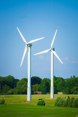 Fototapeta premium Windmill type wind electricity generator in the field in Latvia in summer