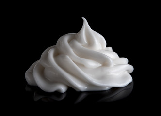 Whipping cream cake or sour cream isolated on black background