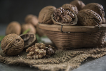 Walnuts in wooden bowl. Whole walnut on table