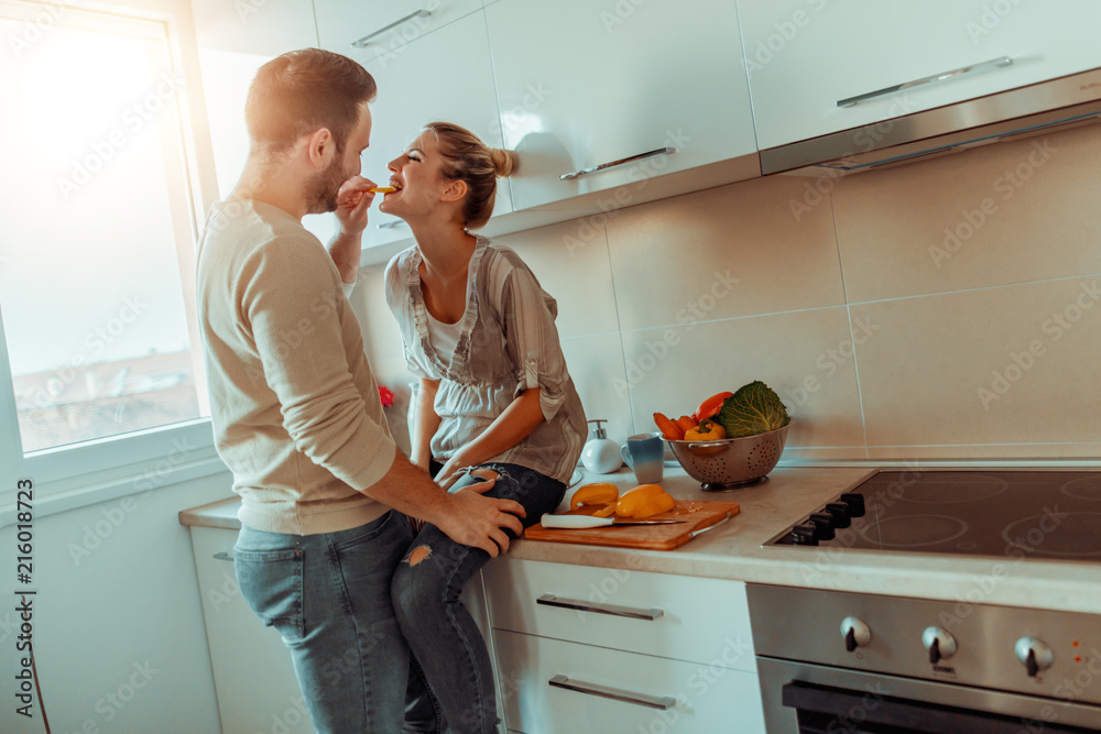 Wall mural romantic young couple cooking together in the kitchen