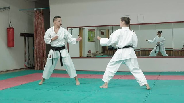 A young man with a muscular body and a woman practicing martial arts Goju-Ryu Karate-Do