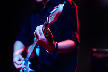 man playing guitar on a stage musical concert close-up view.guitarist plays.