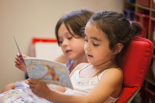 Two students reading a book in a kindergarten classroom. 