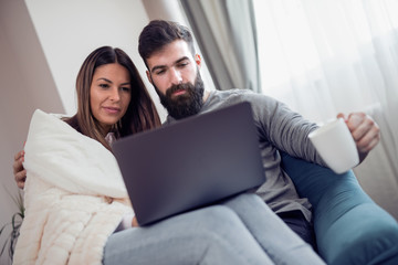 Young couple using a laptop computer at home