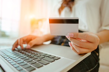 Hands holding credit card and using laptop. Online shopping