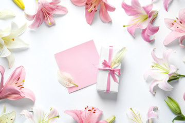 Flat lay composition with beautiful blooming lily flowers on white background
