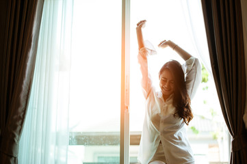 Asian woman waking up in the morning, feeling happy and fresh