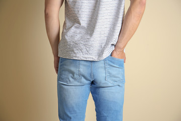 Young man in stylish jeans on light background