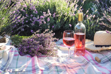 Obraz premium Butelka i szkło wino na koc w lawendowym polu