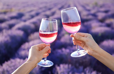 Fototapeta premium People with glasses of wine in lavender field