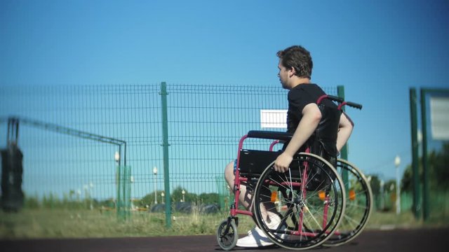 Disabled man plays basketball from his wheelchair, On open air