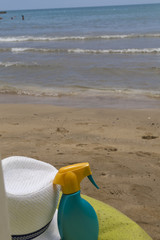 Fototapeta na wymiar summer and travel concept . hat and suntan cream on the beach