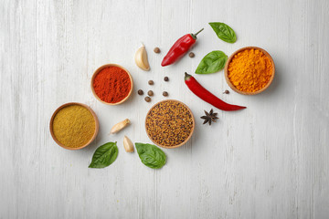 Flat lay composition with different aromatic spices on wooden background