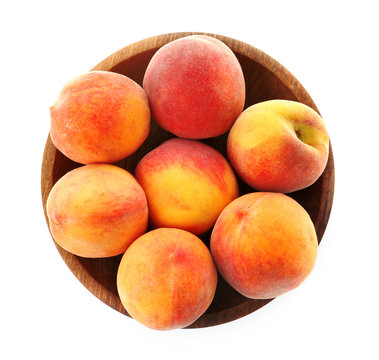 Bowl with fresh sweet peaches on white background
