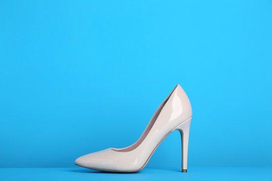 Beige high heel shoes on blue background