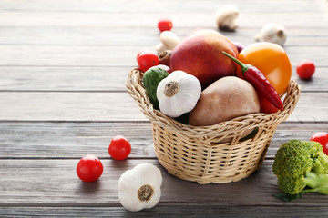 Fresh and ripe vegetables in basket on wooden table