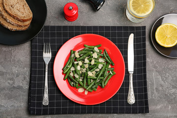 Tasty green beans with almonds served for dinner on table, top view
