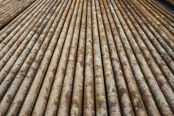 Oil Drill pipe. Rusty drill pipes were drilled in the well section. Downhole drilling rig. Laying the pipe on the deck. View of the shell of drill pipes laid in courtyard of the oil and gas warehouse.