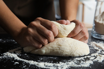 Woman kneading dough for pastry on table