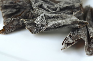 Close up detail of sea salt covered kelp seaweed with copy space on white