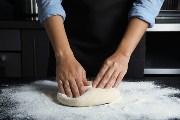 Obraz na płótnie Canvas Woman kneading dough for pastry on table