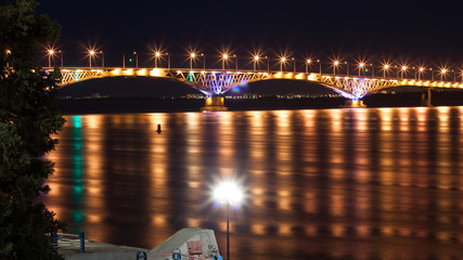 Fototapeta premium Song exposure shot of the brigde above Volga river with beautyfull lights reflected at water