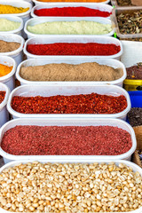 Many multicolored spices in the vessels on the table.
