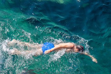 Fototapeta na wymiar Young man swimming at blue sea
