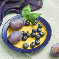 Plums and blueberries in a plate