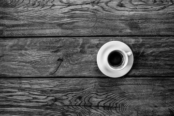 Cup of Coffee, shot from above, clear cup with a wooden plate, isolated on black background