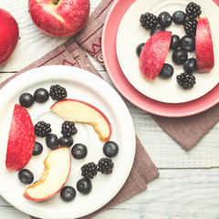 Red apples, blackberries and blueberries in plates