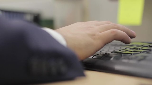 Close up of an office worker's hands, busy typing.