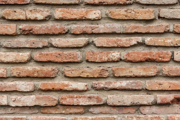 A dark red texture from an old brick wall. A destructive destruction of a brick wall. Brick background for text.