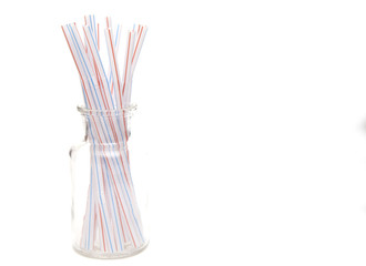 Bunch of Straws in a Glass Container on a White Background