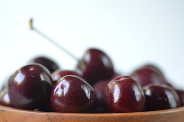 Detail of fresh summer fruit and berries in wooden bowl. Cherries with copy space.
