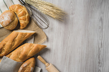 fresh bread and wheat on sack and wooden table.
